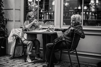 两个女人坐在桌子旁边的灰度照片
